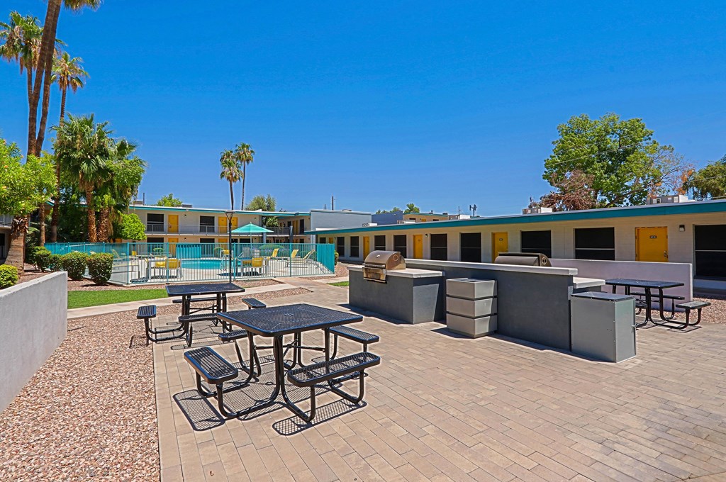 A sunny day at the outdoor picnic area with tables and chairs.