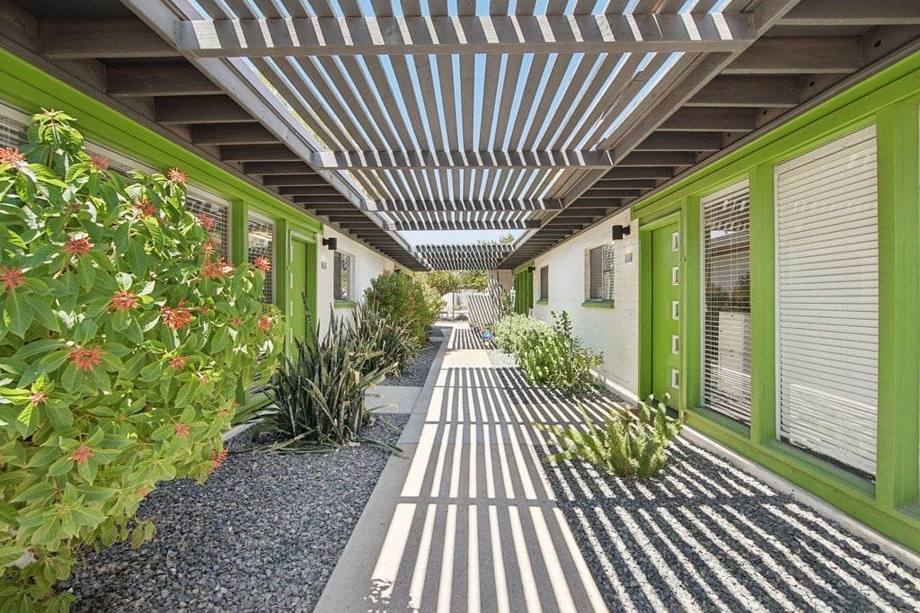 A long hallway with a striped carpet and green walls.