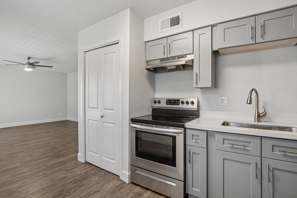A kitchen with a stove, oven, and sink.