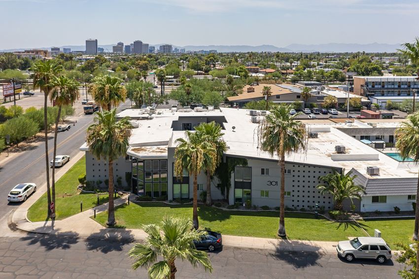 an aerial view of a building with palm trees in front of it
