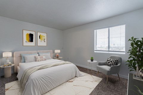 A bedroom with a large bed and a chair.