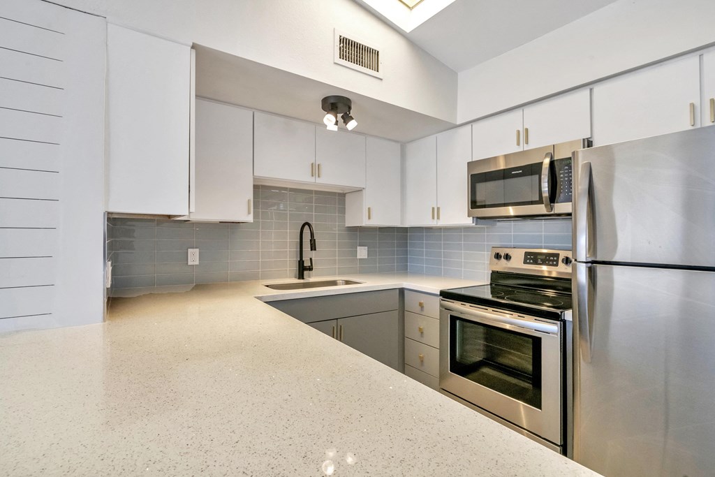 a kitchen with stainless steel appliances and white cabinets