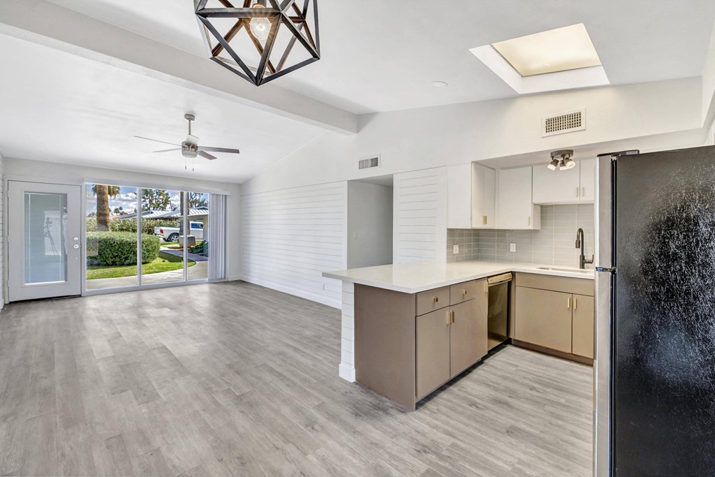 an open kitchen and living room with a door to a patio