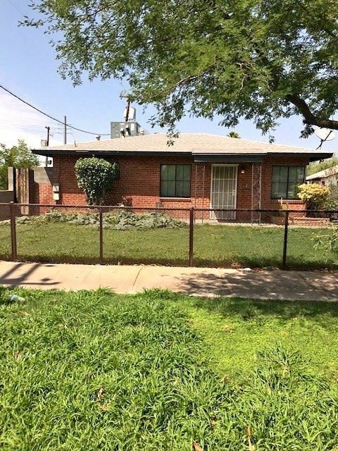 a brick house with a fence in front of it