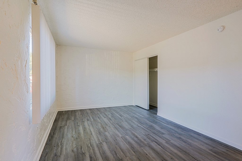 A room with wooden flooring and white walls.