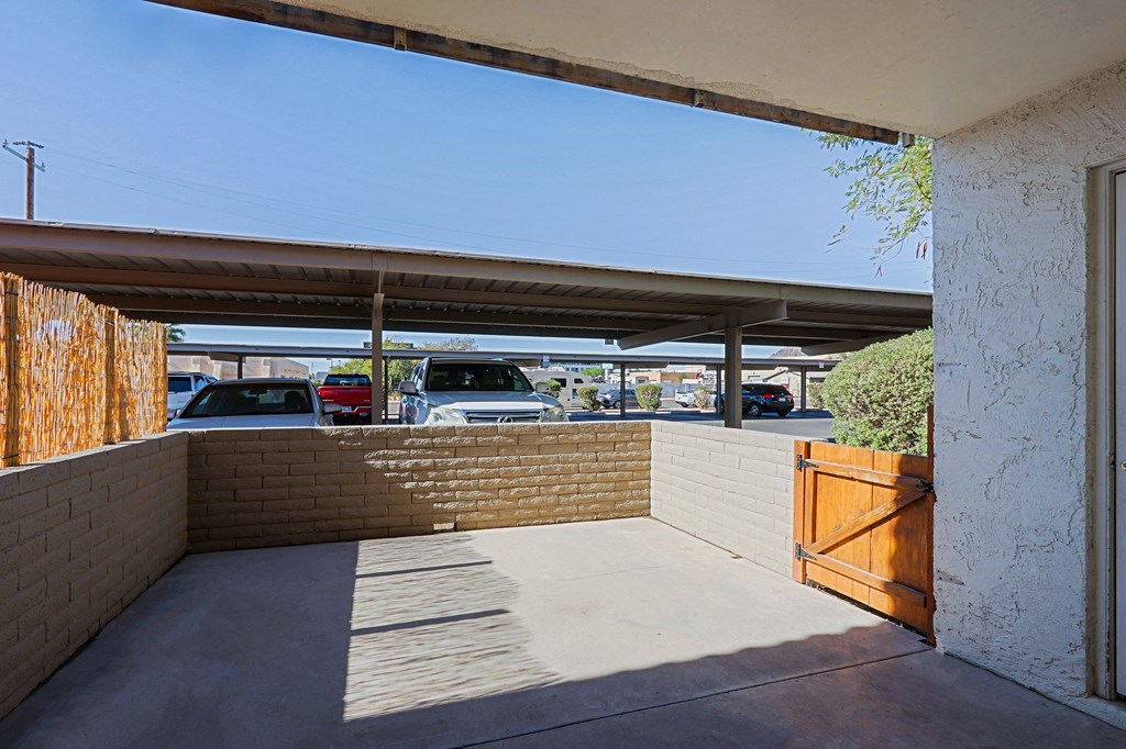 A parking lot is visible through a gap in a fence.