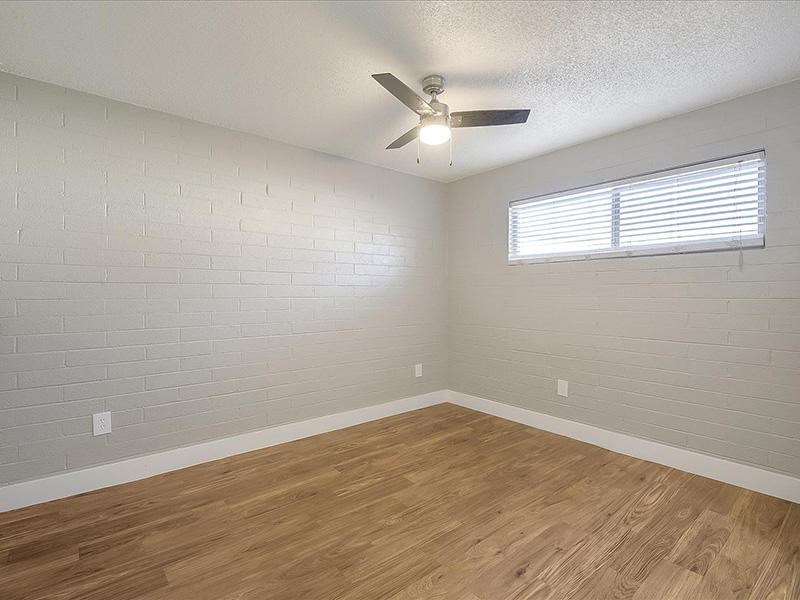 an empty room with a ceiling fan and a window