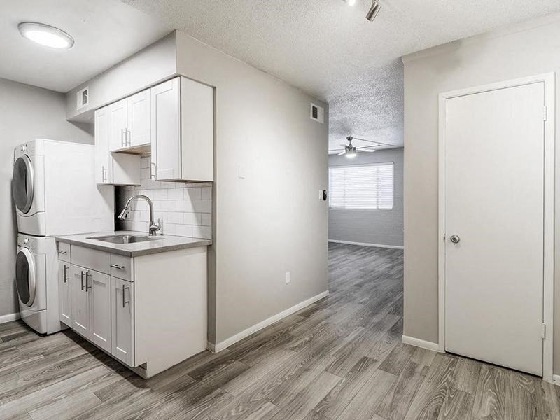 an empty kitchen with a washer and dryer in it
