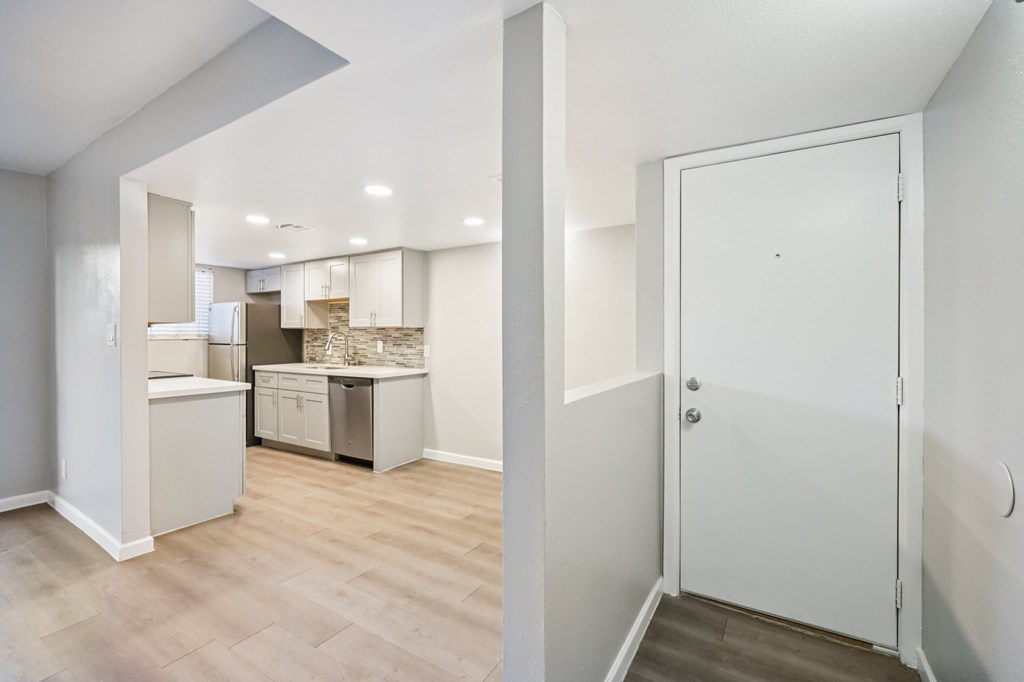 A kitchen area with a refrigerator, dishwasher, and cabinets.