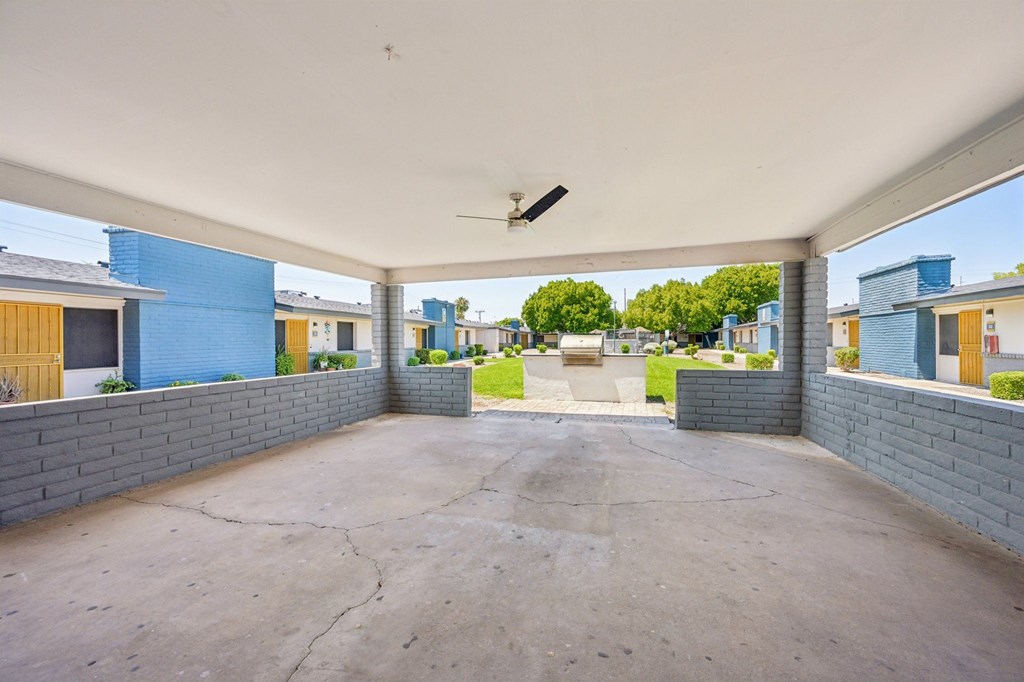 A patio with a concrete floor and a ceiling fan.
