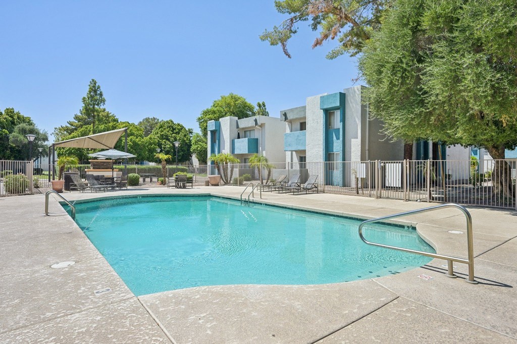 A swimming pool in a backyard with a modern house in the background.