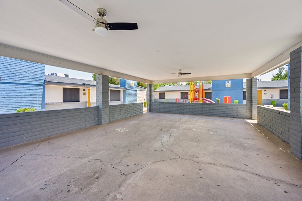 A spacious, empty parking garage with a concrete floor and brick walls.