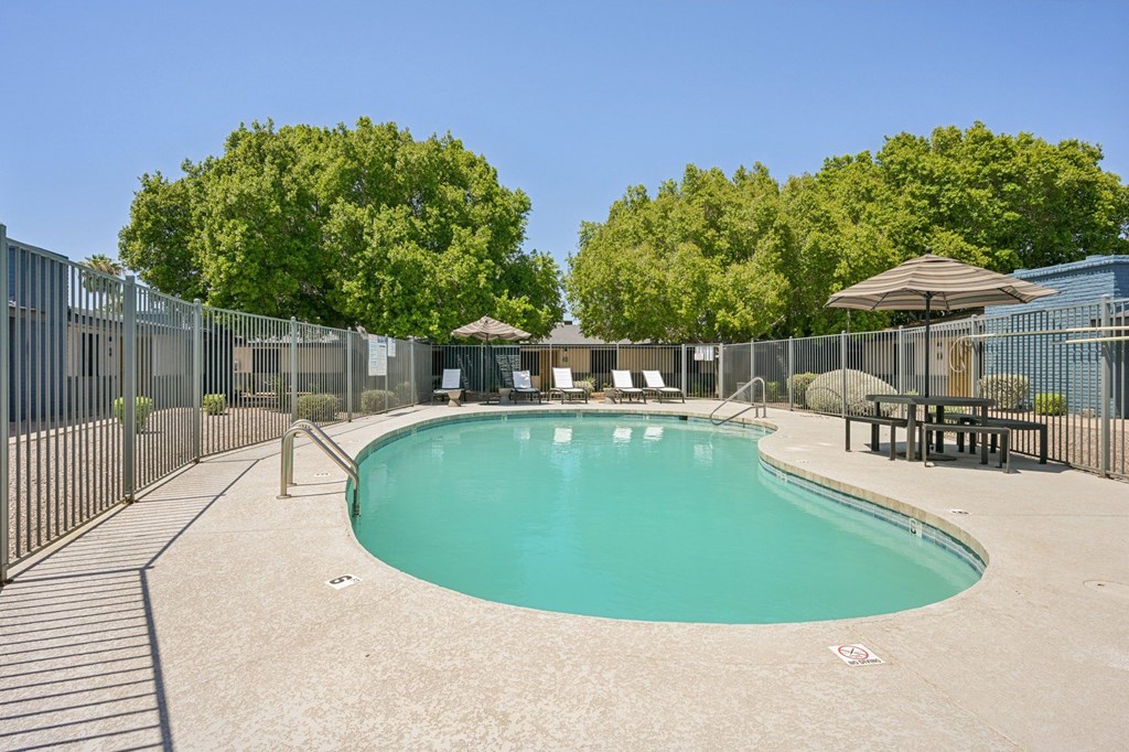 A large outdoor swimming pool surrounded by a fence.