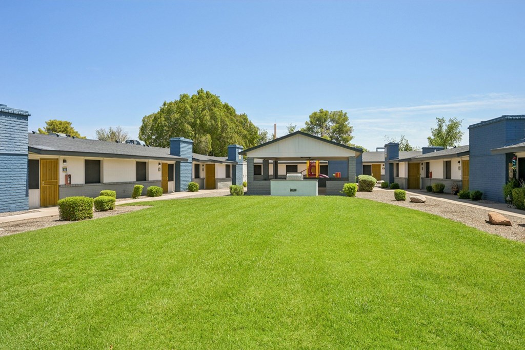 A row of houses with a green lawn in front.