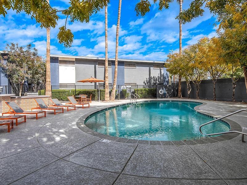 a swimming pool with palm trees next to a building