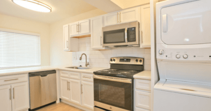 A white kitchen with a black stove top oven.