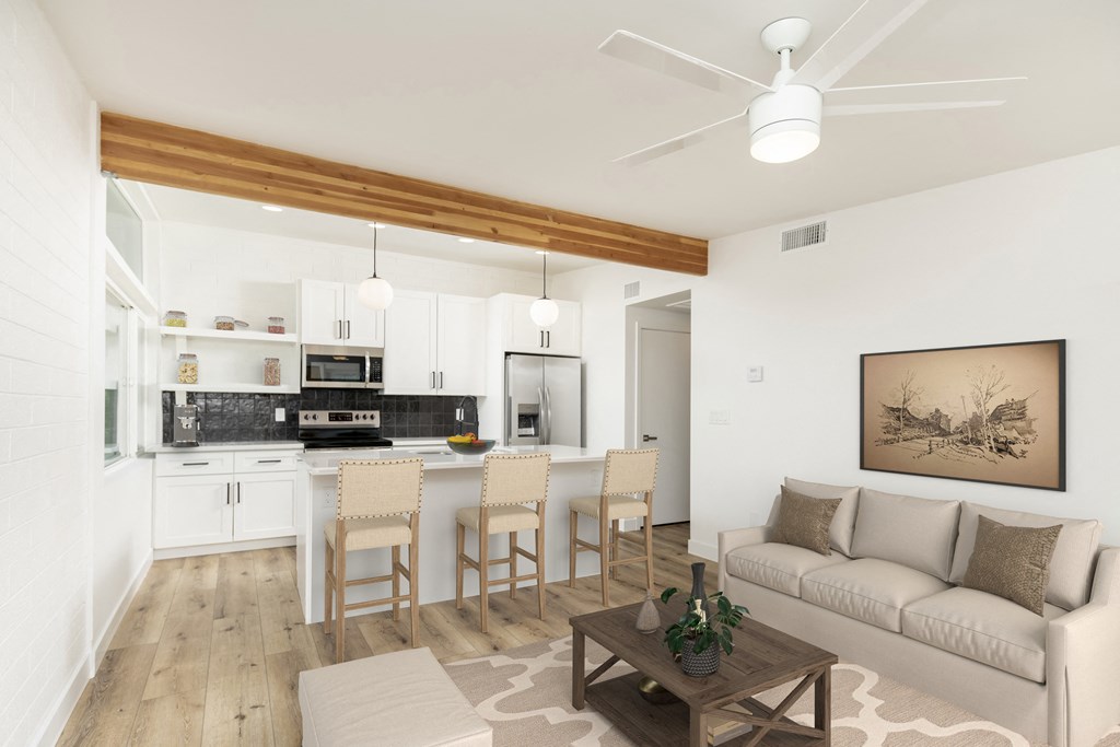 a living room with a couch and a kitchen with a table