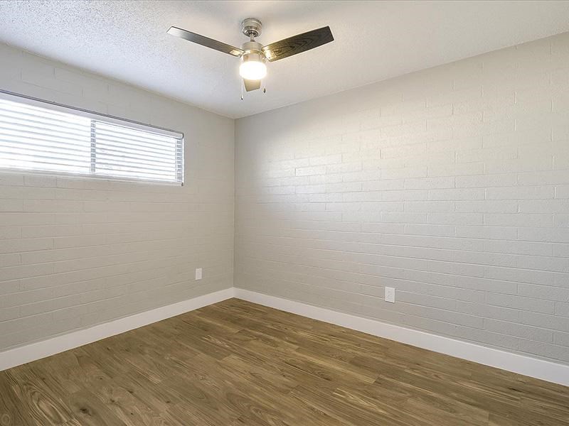 an empty room with a ceiling fan and a window