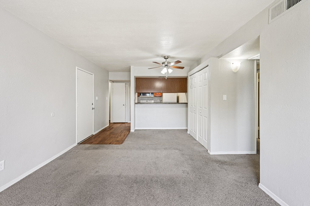 A room with a ceiling fan and a carpeted floor.