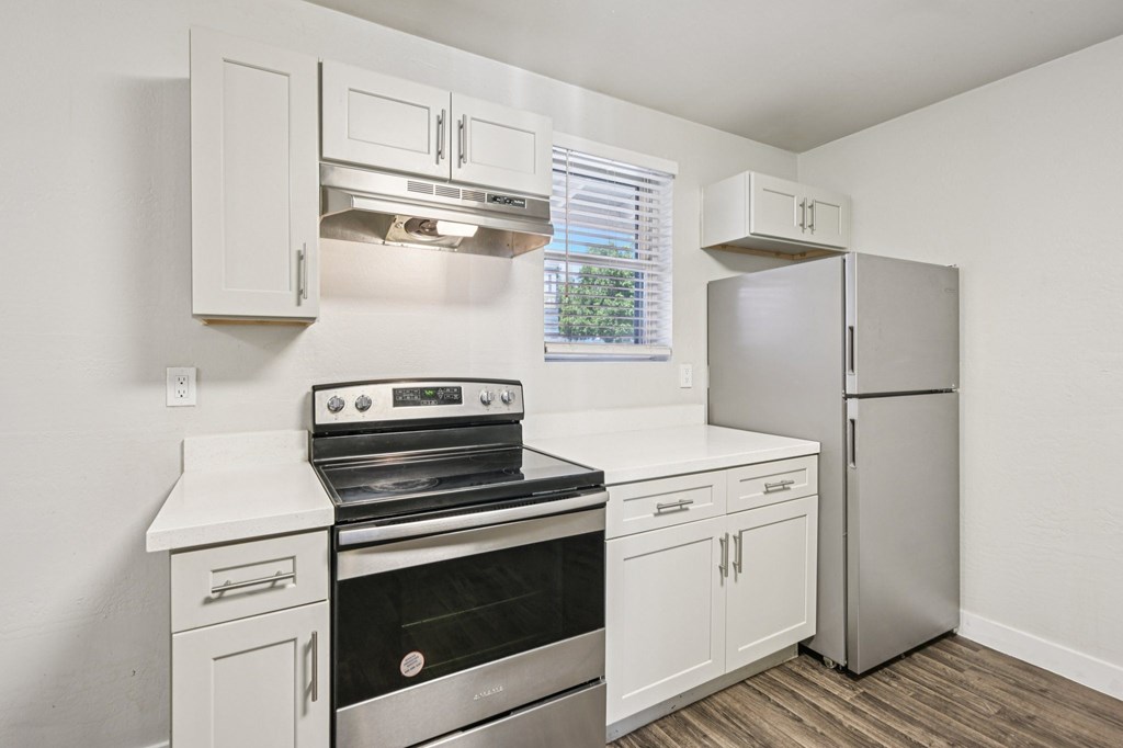 A kitchen with white cabinets and stainless steel appliances.