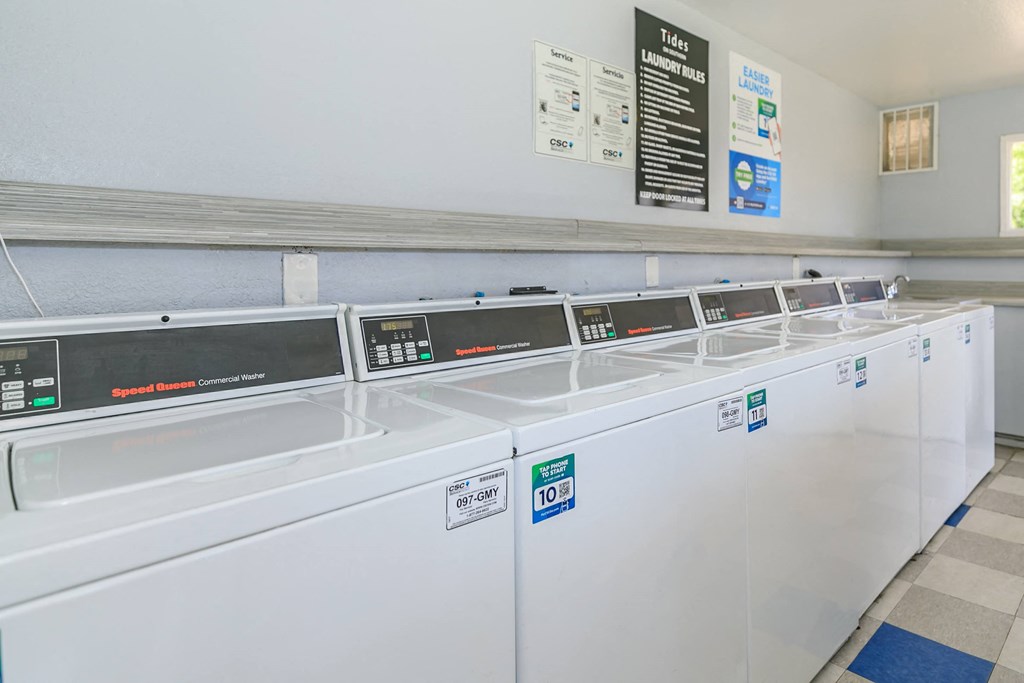 a row of washers and dryers in a laundry room at Tides on Southern, Arizona, 85204