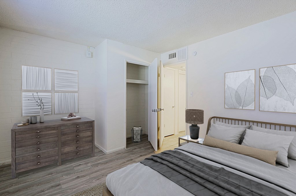 A bedroom with a bed, dresser, and a painting on the wall.