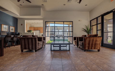 A spacious office with brown leather chairs and a glass table.