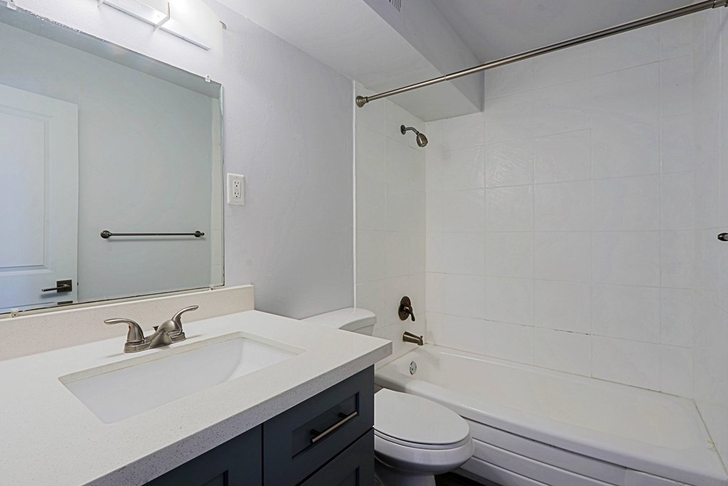 A white bathroom with a sink, toilet, and bathtub.