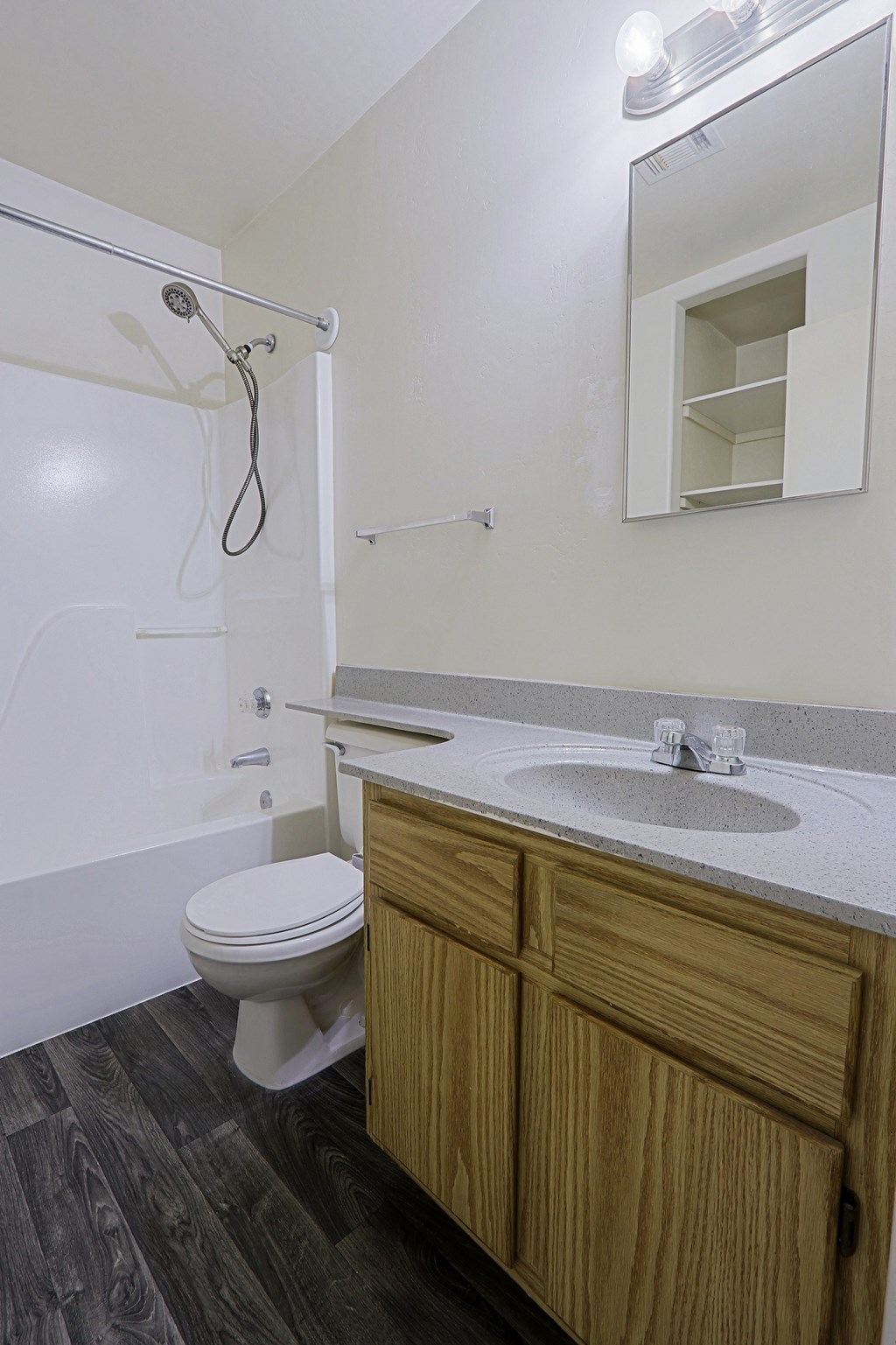 A bathroom with a toilet, sink, and mirror.