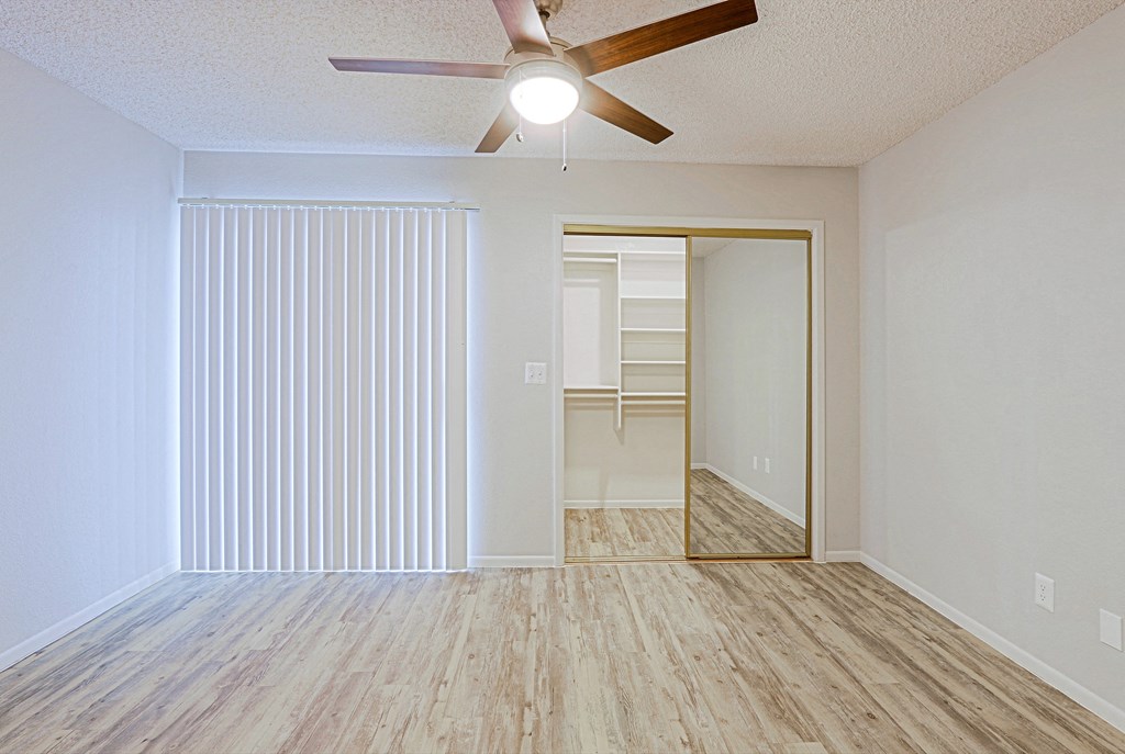 a bedroom with a ceiling fan and closet