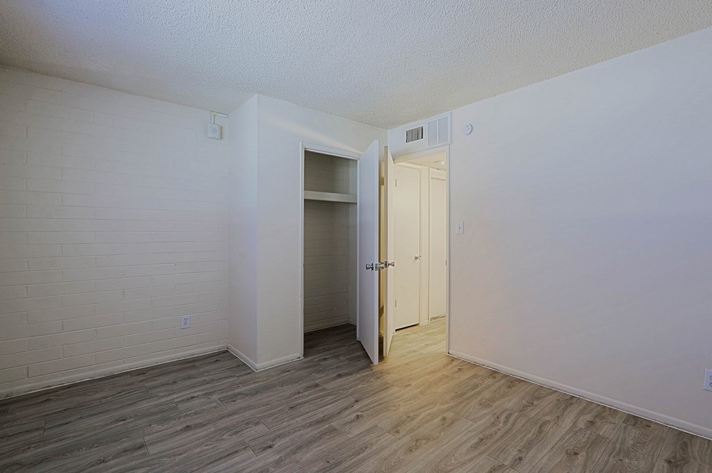 A room with a white wall and a wooden floor.
