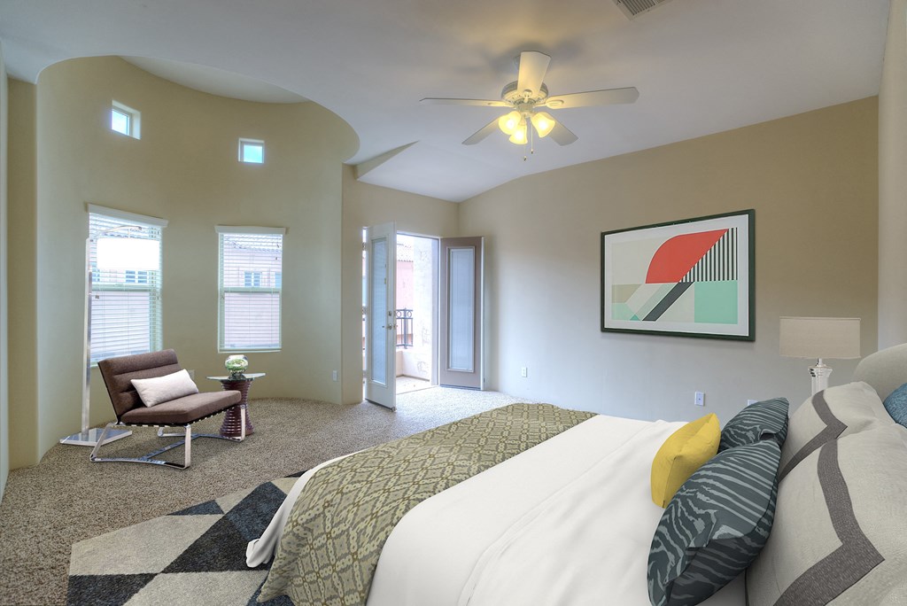 a bedroom with a bed and a chair and a ceiling fan