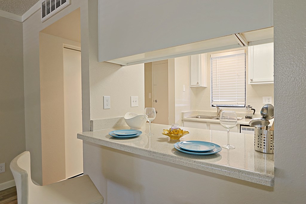 a kitchen with a white counter top and a white chair