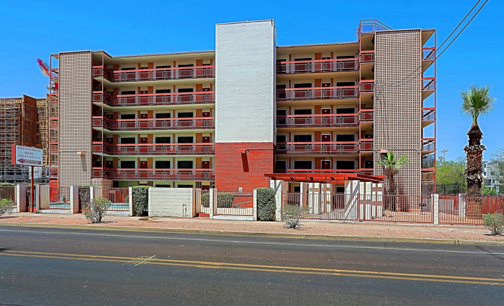 A large red and white building with a palm tree in front.