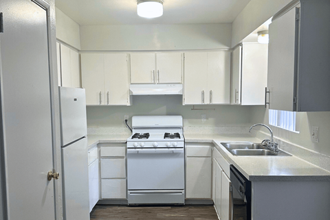 A white kitchen with a stove, sink, and cabinets. at Connect on Missour Apartments, Phoenix, AZ