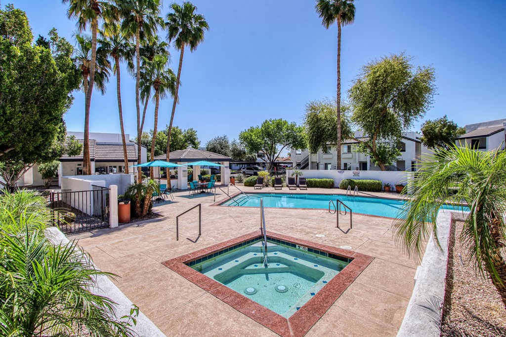 a resort style pool with palm trees and buildings in the background
