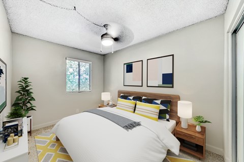A bedroom with a bed, nightstand, and a plant at Connect on Missour Apartments, Phoenix, Arizona