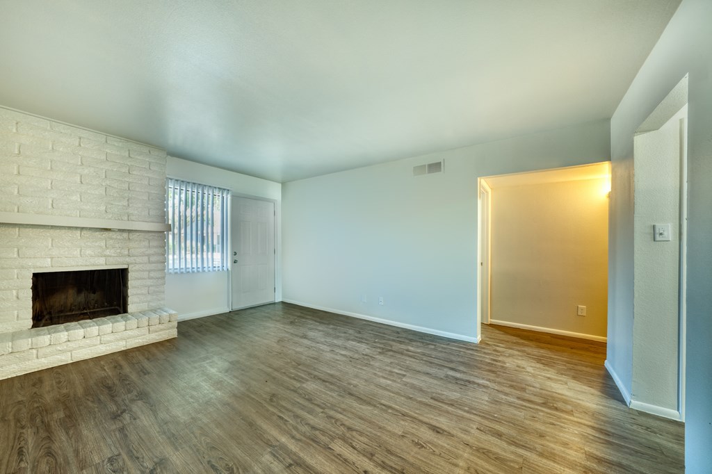 A room with a fireplace and wood flooring. at Connect on University, Mesa, Arizona