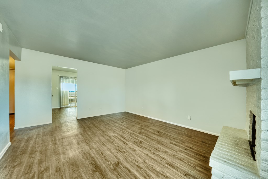 A room with wooden flooring and a fireplace on the right side. at Connect on University, Mesa