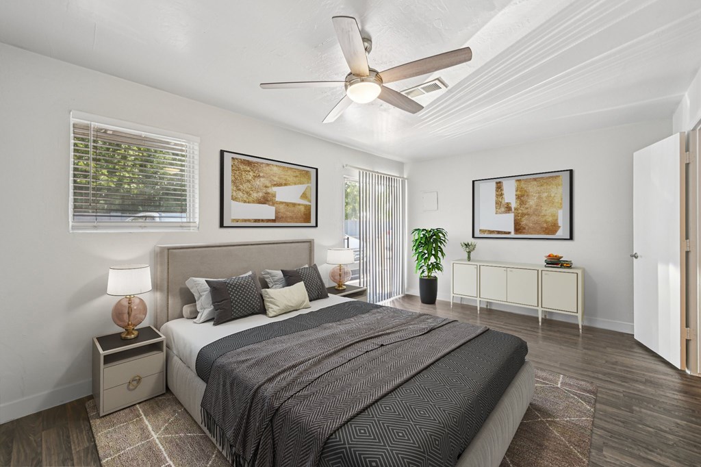 A bedroom with a large bed and a ceiling fan.