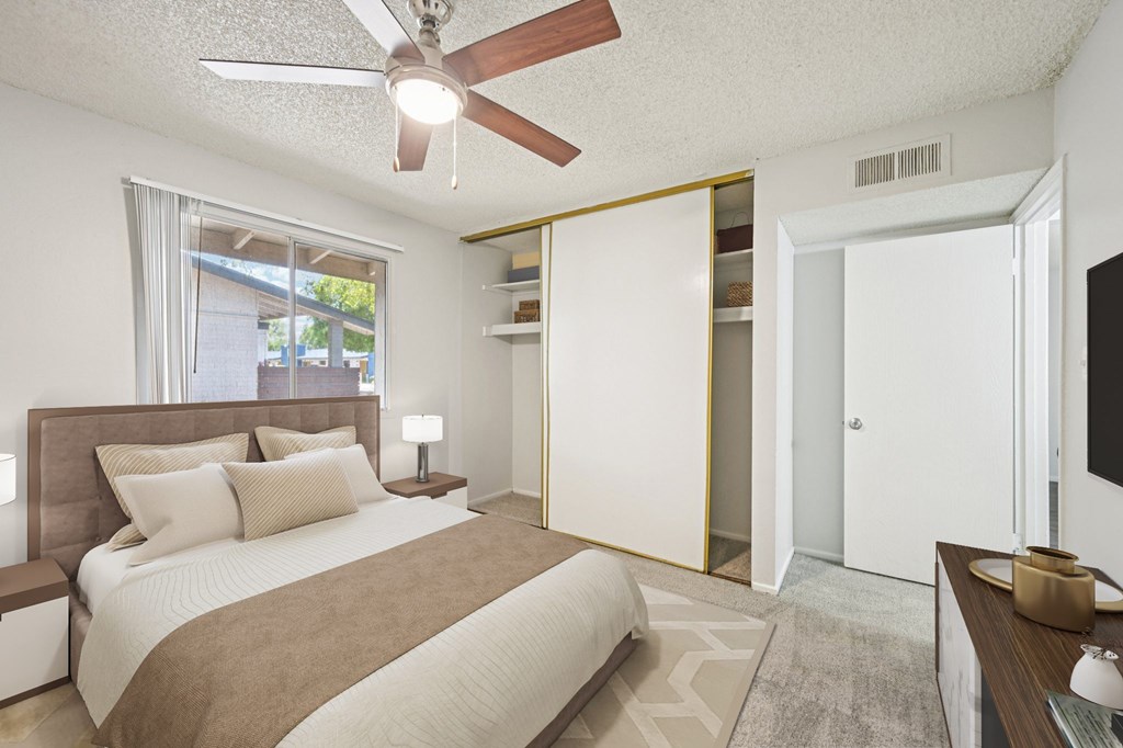 A bedroom with a bed, nightstand, and a ceiling fan.