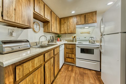 a kitchen with white appliances and wooden cabinets