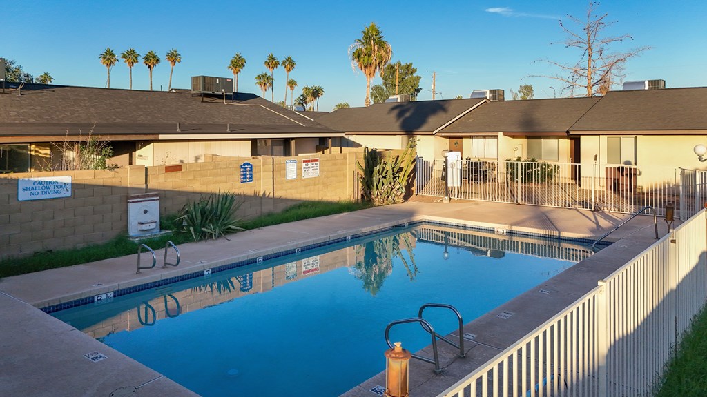 A pool in a backyard with a sign on the wall.