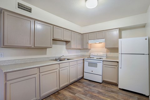 A kitchen with white appliances and wooden cabinets.