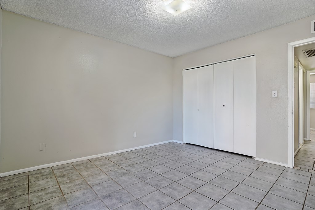 A room with a white wall and a white closet.