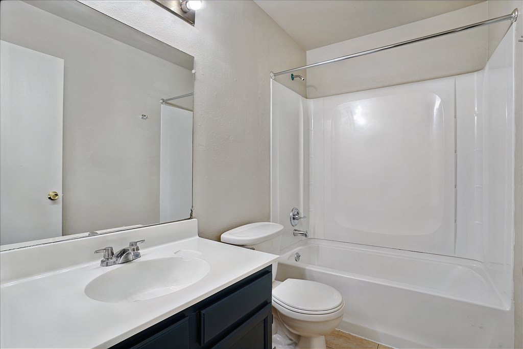 A white bathroom with a sink, toilet, and bathtub.