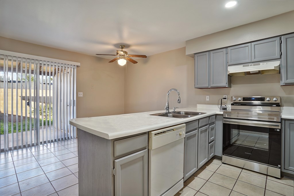 A kitchen with a white countertop and stainless steel appliances.