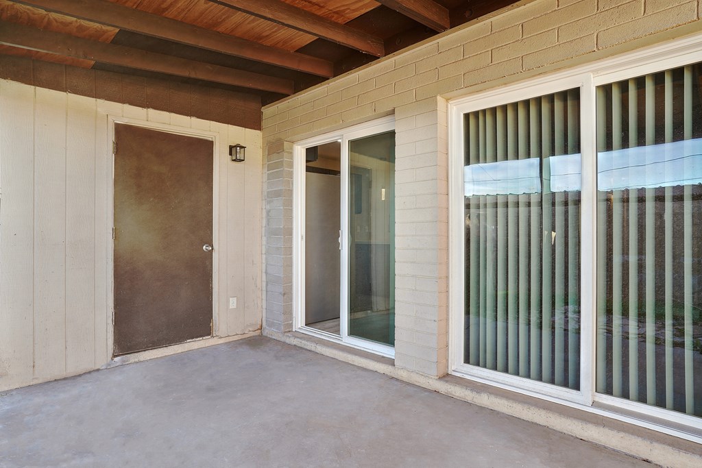 A room with a brown ceiling, a brown door, and a glass door.