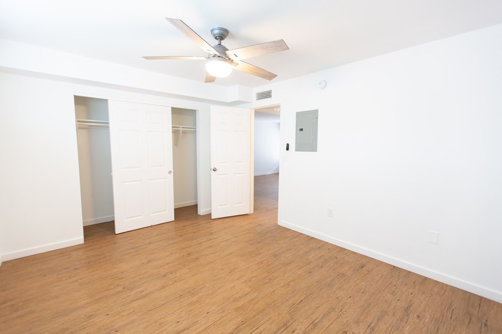 an empty room with white walls and a ceiling fan