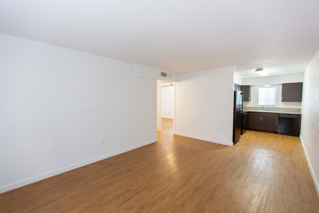 an empty living room with white walls and wood floors
